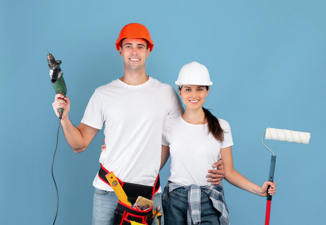 Smiling couple with drill and roller brush